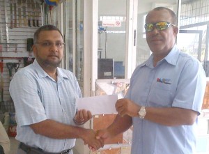 Waqar Sahid (left) of A Ally and Sons hands over the sponsorship to Hubern Evans.