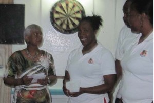 Melissa Smartt (centre) is all smiles after receiving her prize from former national player Pamela Williams(left)  in the presence of her doubles partner Natisha Fordyce.