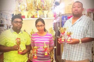 Representatives of Imran & Daughters show off the trophies along with RHTY&SC Secretary/CEO, Hilbert Foster at right.