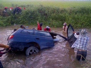 Rescuers trying to get the overturn vehicle out of the water.