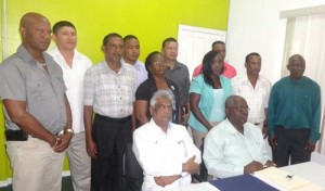 GECOM Chairman Dr. Steve Surujbally (sitting at left) and Chief Elections Officer Keith Lowenfield, with Returning Officers in the background.