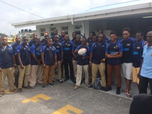 The Barbados national rugby team and Management pose for a photo op after arriving at the Ogle International Airport yesterday. 