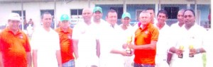 President of the Lusignan Community Centre Rocky Ramgopaul (right) presents the winning trophy to captain of the Lions team Rajesh Singh in the presence of his team mates. 
