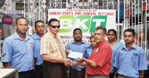 Justice (Rtd) Cecil Kennard (second left) accepts the sponsorship cheque from Managing Director of Ganesh Parts and General Store, Robb Street, Lacytown, Roop Persaud in the presence of the store’s employees.