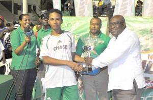 Tournament Most Valuable Player Isaiah Reddy of Chase Academy received his trophy from a Ministry of Education official yesterday.