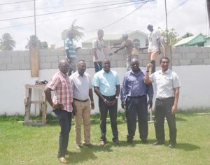 K&S has joined forces with DCC to lift the height of their fence. From left: Aubrey ‘Shanghai’ Mayor, DDC President Alfred Mentore, Ian John & Kashif Muhammad with the workers in the background.