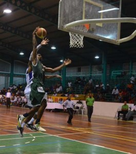 Guyana’s, Akeem Kanhai sails to the basket for a one-handed dunk with Bermuda’s, Sullivan Phillips trying to defend the inevitable.