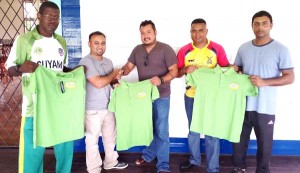 Fawaz Mohamed (second left) of Tiger Sports presents one of the shirts to Media XI skipper John Ramsingh. Sharing the moment are, from left, media players Calvin Roberts, Avenash Ramzan and Zaheer Mohamed.