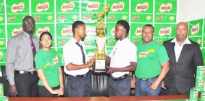 Captains Kareem Knights (3rd right) and Shawn Mohamed pose with the winning trophy along with Nestle Brand Manager Renita Sital, Petra Organisation Co-Director Troy Mendonca (2nd right) and teachers Henry Chase (right) and Joel Porter yesterday.