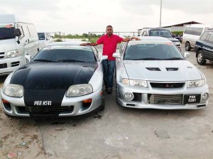 Anand Ramchand poses next to two of his cars that will participate in today’s Drag Race Meet.