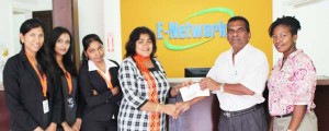 Reps of E Networks Company (left) present a cheque to Secretary of the PMTC.