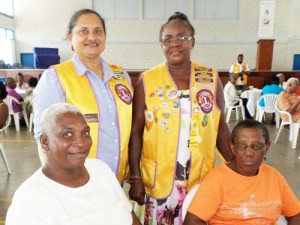 Current President Zaleena Lawrie (standing, left) and Health and Service Chairperson Patricia Gray (standing, right) with two of the persons treated to an afternoon of entertainment.