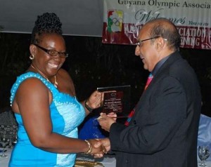 The late Shanomae Blackmore (left) collecting an award from the GOA President, K.A. Juman Yassin for her outstanding contributions to sports last year.