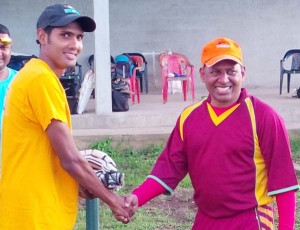 Tiger sport donation: Proprietor of Tiger Sports and former national wicketkeeper/batsman, Sheik Mohamed (right), presents a pair of batting glove to Guyana Media XI opener, Ravi Persaud.