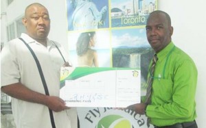 Fly Jamaica’s Wesley Tucker (right) hands over airline ticket to RHTY&SC’s Hilbert Foster. 