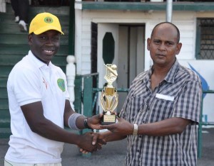 Essequibo’s Akieni Adams collects his man of the match prize from selector Nazimul Drepaul 