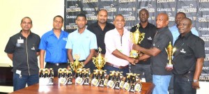 Banks DIH official Josh Torrezao (5th right) hands over the winning trophy to Co-ordinator Phillip Carrington in the presence of Company officials yesterday.