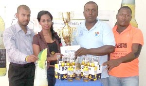 Captain of d Edward Jaipur Harripaul (right) accepts the trophy and cheque from Ms. Devi of Top Brandz in the presence of Abel Seetaram (left) and Keith Fraser. 