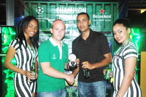 Heineken Brand Manager, Robert Hiscock (second, left) hands over an official Heineken UEFA branded wrist watch to Kishon Gorakh, who won the Foosball Competition Saturday night at the Altitude Cocktail Bar and Lounge.