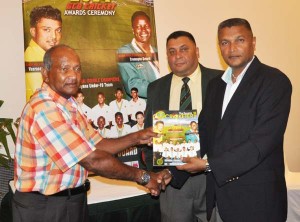 Alvin Kallicharran (left) accepts a copy of “The Guyana Cricketer” from GCB secretary Anand Sanasie in the presence of Marketing manager Raj Singh. 