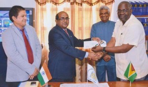 Indian High Commissioner, V. Mahalingam, presenting the cheque to Chief Election Officer, Keith Lowenfield with Chairman, Dr. Steve Surujbally looking on. At left is the Indian High Commission’s Second Secretary, S.M Joshi.