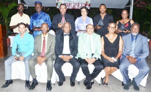 IOC Member, Sir. Austin Sealy (third, left) and GOA President, K.A. Juman Yassin (fourth, left) join other GOA Council Members (seated) and Awardees (standing), following the Appreciation and Awards Ceremony Saturday night at Georgetown Club.