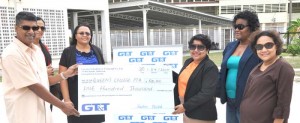 GT&T Senior Marketing representative Anjanie Hackett hands over the cheque to Queen’s College PTA President Neil Persram in the presence of Company officials Nadia DeAbreu (right) and Allison Parker (2nd right) and Headmistress Jackie Benn-Ralph (3rd left) yesterday. 