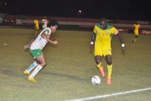 Guyana’s Captain Dwain Jacobs seeks to get past Suriname’s Bruce Diporedjo last night.