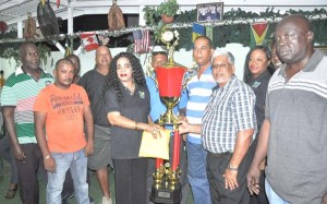 President of the GDA Faye Joseph (3rd left) hands over the lucrative first prize and winning trophy to members of the victorious Rage team on Wednesday evening at her residence.