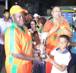 Karibee Girls captain Erva Giddings collects the Nand Persaud Memorial Trophy from Romeo Deonarain.