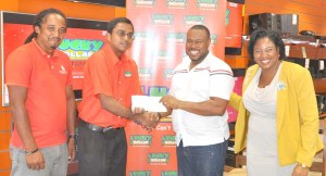 Lucky Dollar Chain Manager Robert Arjoon (2nd left) hands over the cheque to Petra Organisation Troy Mendonca in the presence of Store Manager Sharon Persaud and a Petra official.  
