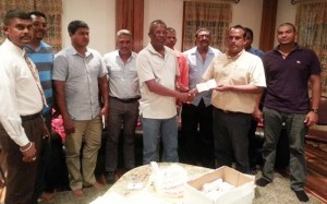 Mr Peter Lewis of Peter Lewis Construction Services hands over sponsorship cheque to Vijai Ramdhan, member of the organising committee in the presence of Region Six Chairman, David Armoogan as other friends of the PPP/C look on. 