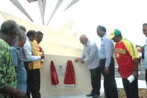 President Donald Ramotar and Prime Minister, Samuel Hinds with assistance from Minister of Culture, Youth and Sport, Dr. Frank Anthony pull the string that unveils the plaque to officially signal the opening of the National Track and Field Centre at Leonora yesterday. 