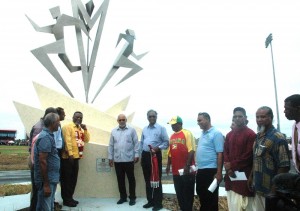 President Donald Ramotar and Prime Minister, Samuel Hinds among Government and other officials stand in front the monument that stands at the entrance of the National Track and Field Centre at Leonora yesterday.