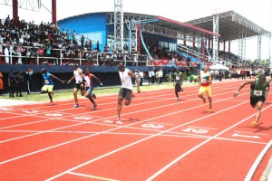Rupert Perry (fourth, left) leans across the finish line in 10.1 seconds yesterday in the Men’s 100m that marked the opening of the Synthetic Track and Field Facility at Leonora.