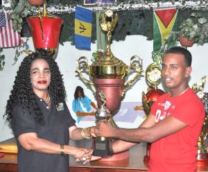 Tournament MVP Kanhai Samaroo receives the trophy from GDA President Faye Joseph.
