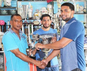 Managing Director of Trophy Stall Ramesh Sunich hands over one of the trophies to Organiser Nazrudeen Mohammed Jr. Also in pic is Ricky Azrula.