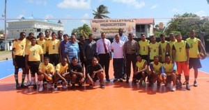 The group of officials and players on the new volleyball surface.