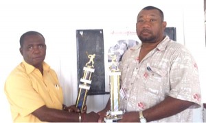 Mr. Brown of Sentinel Security Ltd hands over trophies to RHTYSC Secretary/CEO Hilbert Foster.