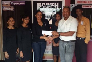 CEO of BAKSH TRAVEL SERVICE, Mrs Maria Baksh (left), hands over a cheque to Nigel Trotz of the Blairmont Cricket Club. 