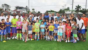 FIH, PAHF and GHB Presidents Leandro Negre, Alberto ‘Coco’ Budeisky and Philip Fernandes (centre) pose with young players at yesterday’s on site visit at the GCC ground.