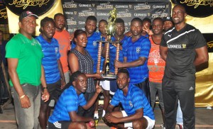 Linden Branch Manager Shondell Easton hands over the first prize money and winning trophy to Amelia’s Ward Russians captain, Travis Waterton in the presence of Guinness Brand Manager Lee Baptiste (right) and teammates on Monday night at the Mackenzie Market tarmac.