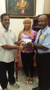 Mr. N. Mohammed (left) of Mohammed’s Enterprise hands over their sponsorship to Max Massiah as Laura Creavalle look on. 