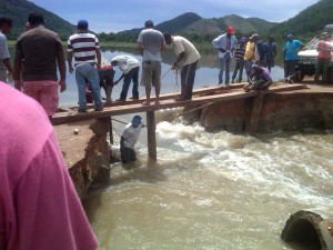 Travellers were forced to construct a makeshift bridge to cross over a washed away section