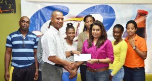 Ansa McAl PRO, Darshanie Yussuf (third, right) hands over the sponsorship cheque to President of the AAG, Aubrey Hutson yesterday in the presence of athletes and Coach, Robert Chisholm (left).