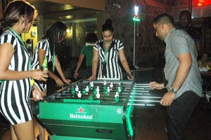 Heineken models engage a participant in a foosball game Thursday night at Altitude Bar and Lounge, Sandy Babb Street, Kitty.