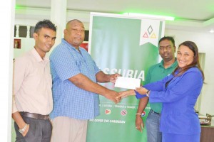 Assuria Rose Hall Town Branch Manager Julie Fraser hands over cheque to Hilbert Foster in presence of General Manager Yogindra Arjune.