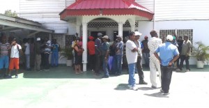Some of the workers who waited until the afternoon for their cheques while others lined up inside.