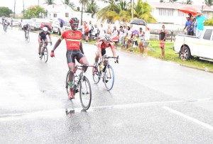 Hamza Eastman celebrates as he crosses the finish line ahead of Alanzo Greaves (right) and Geron Williams to win the GCF Senior Road Race yesterday. (Franklin Wilson photo) 