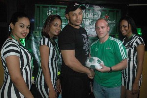 Heineken Brand Manager, Robert Hiscock (second, right) presents a prize to Kwame Christian-McRae Thursday night at Altitude Bar while models share the moment. 